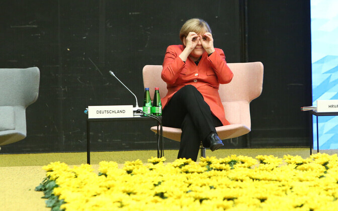 Tallinnas viibinud Angela Merkel piilub ajakirjanikke ja kolleege läbi sõrmebinoklite.