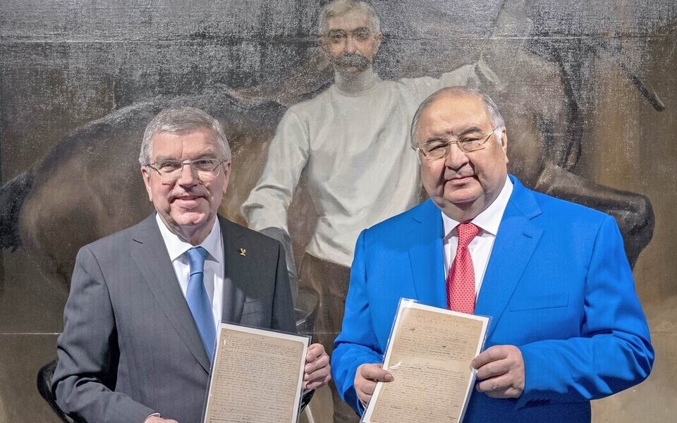 Venemaa miljardär Ališer Usmanov (paremal) annetas Pierre de Coubertini manifesti olümpiamuuseumile, andes selle üle ROK-i presidendile Thomas Bachile.